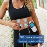 Electrical muscle stimulation pads on a woman's torso for muscle building.