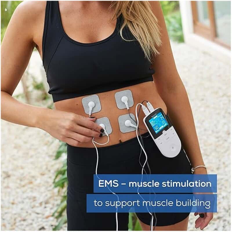 Electrical muscle stimulation pads on a woman's torso for muscle building.