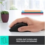 Hyper-fast scrolling mouse on a white desk with books and plant in background.